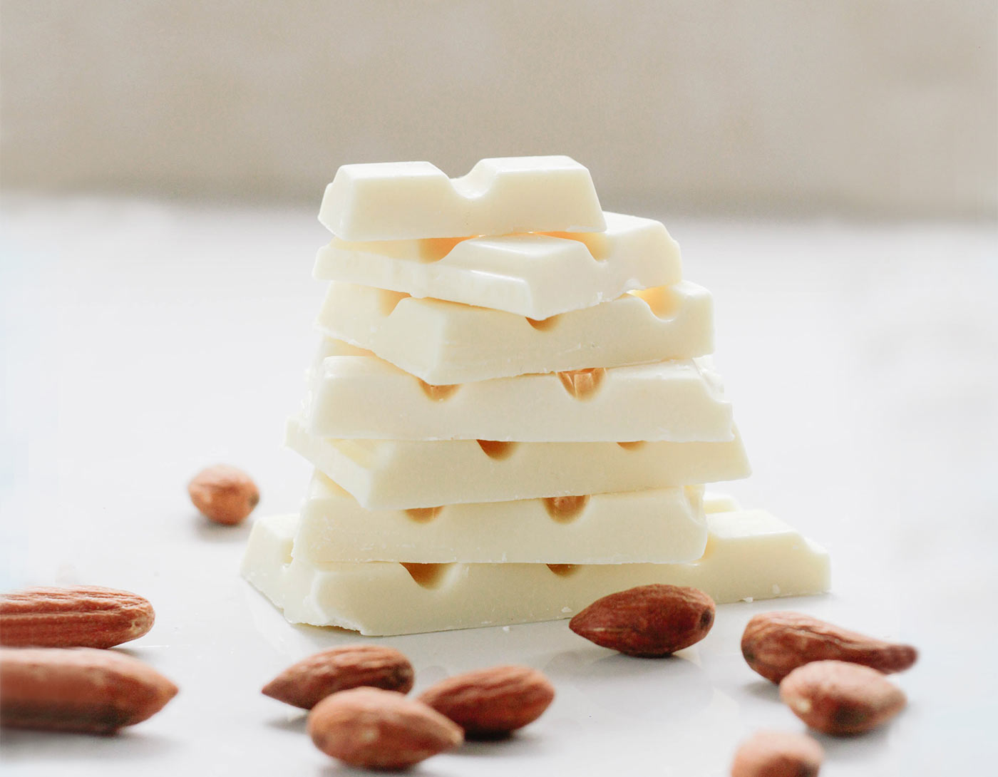 A stack of white chocolate bars and almonds.