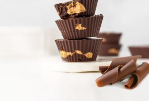 A stack of chocolate cups with peanut butter on top.