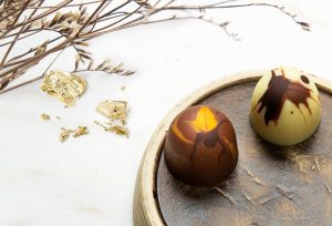 Two chocolate candies on a wooden plate