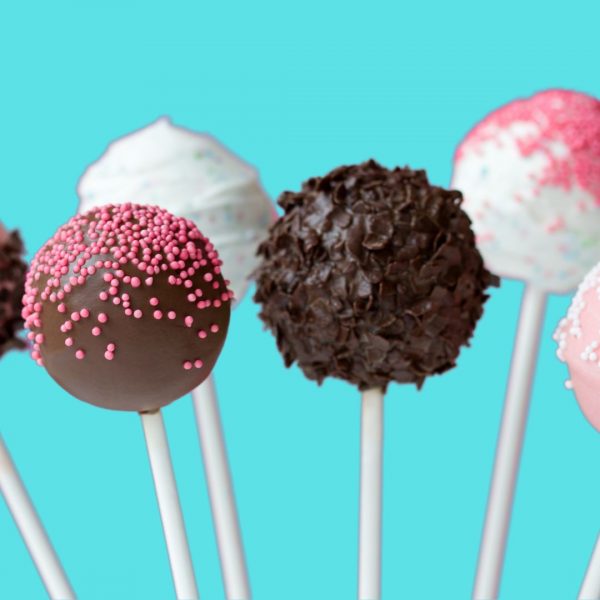 A row of cake pops with different flavors on them.