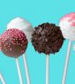 A row of cake pops with different flavors on them.