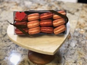 A box of red and white cookies on top of a table.