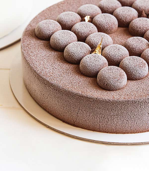 A cake with chocolate frosting and candles on top.