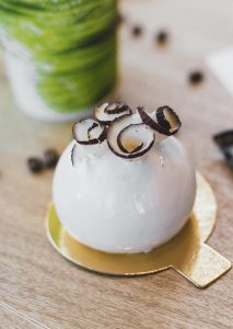 A white cake with chocolate and coconut on top.