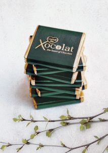 A stack of chocolate bars with the logo xocolat on them.