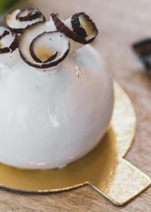 A white vase with chocolate and vanilla swirls on top of it.