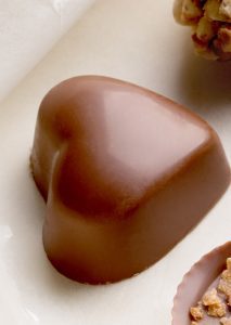 A close up of a chocolate heart shaped candy.