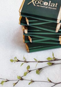 A stack of green matches next to a branch.