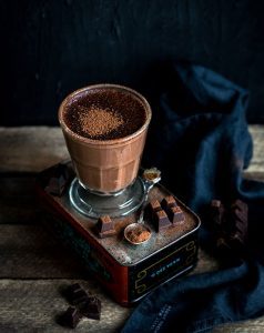 A cup of chocolate on top of a table.