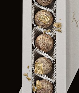 A box of four chocolate covered cookies with gold foil.