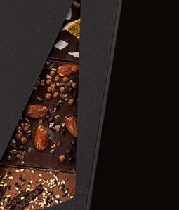 A chocolate bar with nuts and raisins on top of it.