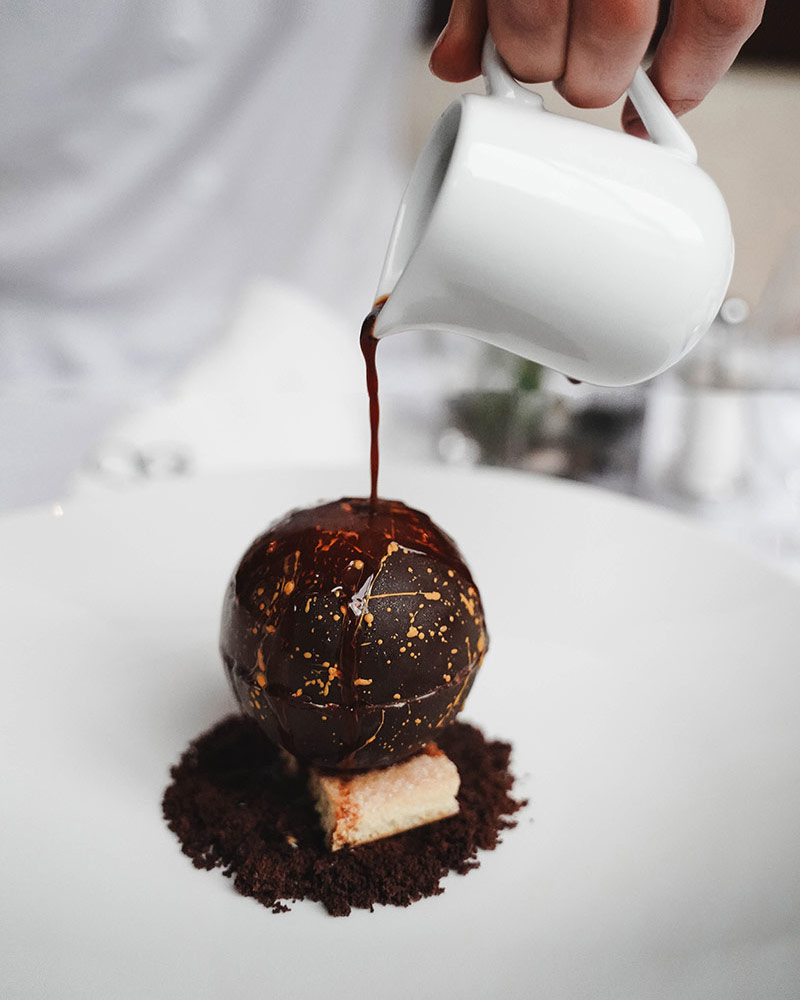 A chocolate apple being poured into a cup.