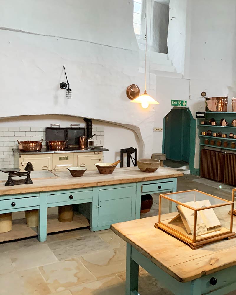 A kitchen with many wooden tables and bowls