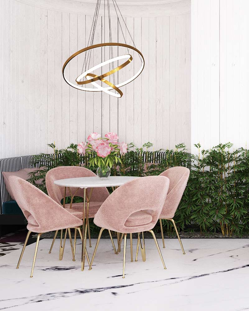 A table and chairs in front of a wall with plants.