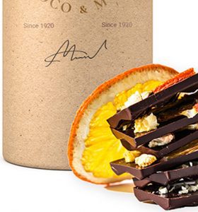 A bottle of wine and some chocolate with an orange.