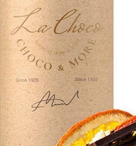 A bottle of wine with an orange and chocolate on the side.
