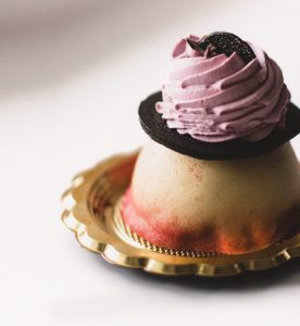 A cupcake with pink frosting on top of it.