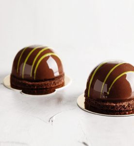 Two chocolate cakes on a plate with yellow stripes.