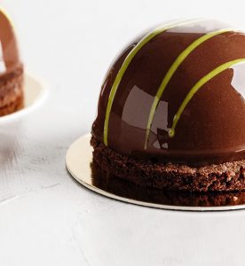 A chocolate cake with yellow and white stripes on top.