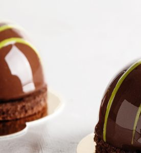 Two chocolate cakes on a plate with yellow stripes.