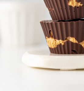 A close up of two chocolate cups on a plate