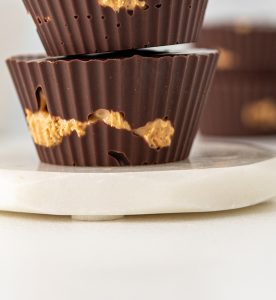 A close up of two chocolate cups on a plate