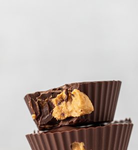 A close up of two chocolate cups with peanut butter