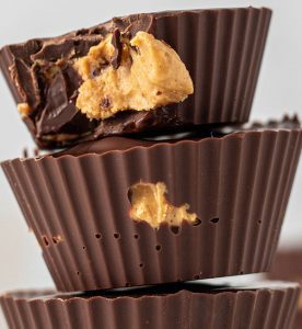 A stack of chocolate cups with peanut butter on top.