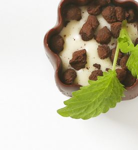 A bowl of food with some leaves on the side.