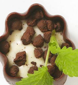 A bowl of food with some leaves on the side