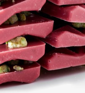 A stack of pink chocolate covered pistachios.