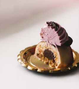 A piece of cake with pink frosting on top.