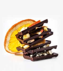 A stack of chocolate bars next to an orange.