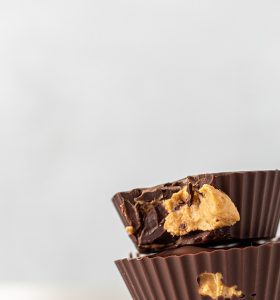 A close up of two chocolate cups with peanut butter