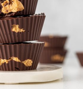 A stack of chocolate cups with peanut butter on top.
