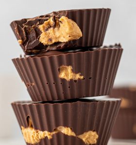 A stack of three chocolate cups filled with peanut butter.