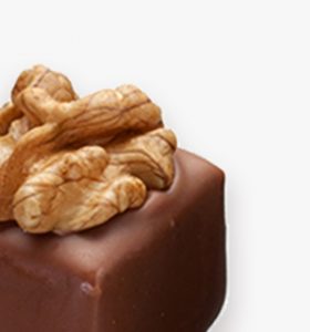 A close up of some nuts on top of a chocolate cake