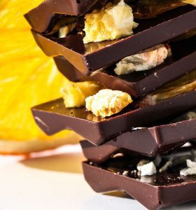A stack of chocolate bars with nuts and orange slices.