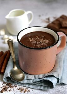 A cup of hot chocolate on top of a napkin.