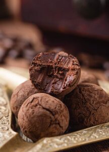 Chocolate truffles arranged on a decorative plate.