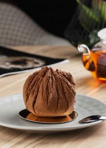 A bowl of chocolate ice cream on a plate.