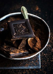 A bowl of chocolate and other ingredients on the table.