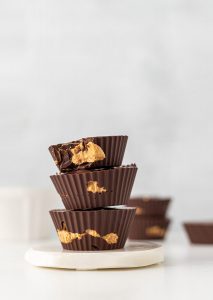 A stack of chocolate cups with peanut butter on top.