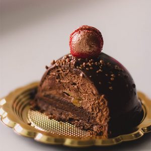 A chocolate cake with a candy ball on top.