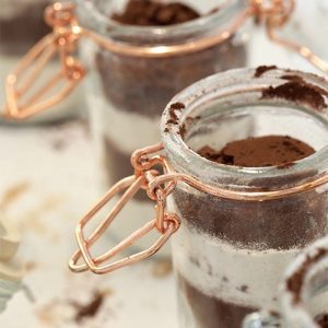 A close up of two jars with chocolate and white frosting