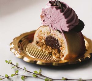 A piece of cake with purple frosting on top.