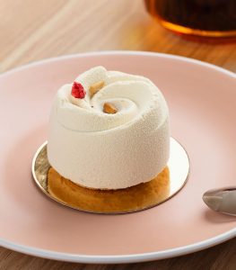 A small cake on top of a pink plate.