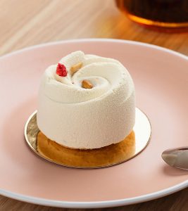 A small cake on top of a pink plate.