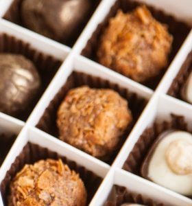 A close up of several different chocolates in a box