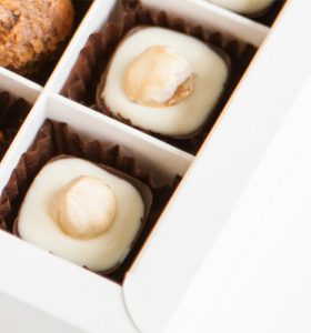 A box of chocolates with white chocolate and nuts.